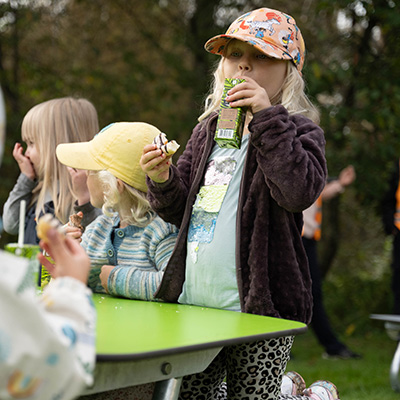 Girl enjoying a snack at the Linnea Picnic Table in HPL.